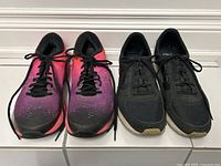 Both pairs of women's running trainers side by side on the floor, showing overall condition and size 9 indication.