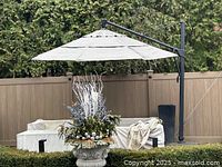 Deployed offset umbrella over patio seating, showing full canopy and arm