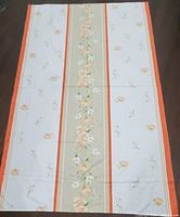 Full view of rectangular tablecloth laid flat showing pattern and colors.