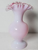 Full view of handblown vase showing pink and white gradient with clear ruffled top