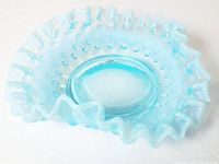 Blue opalescent square candy dish with hobnail pattern and ruffled edge photographed on white background, showing full item.
