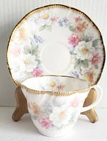 Front view of teacup and saucer showing floral pattern and gold trim.