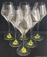Set of six new white wine crystal goblets photographed on a black background showing clear crystal and modern design.