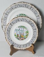Two side plates displayed on a wooden stand, showing the Silver Birch design and the birch bark textured rim.