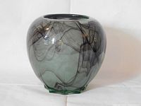 Front and side view of rounded glass vase showing smoky swirling darker lines inside translucent gray-green glass with ground bottom.