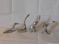 All four Hoselton sculptures arranged side by side on white cloth background