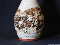 Close-up of the ceramic vase highlighting the textured brown and white glaze on the midsection and the terracotta base.