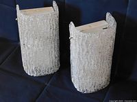 Pair of sconces angled view showing textured glass and porcelain backs