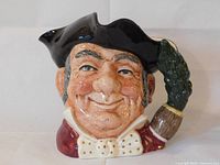 Close-up of the Royal Doulton character mug showing detailed facial features, clothing, and tricorn hat with feather handle.