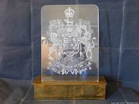 Front view of lamp showing clear Lucite panel with etched Canadian Coat of Arms mounted on brass base