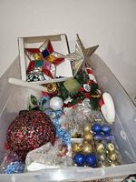 Box with mixed ornaments, garlands, candle and picks