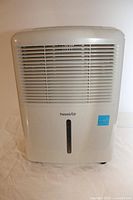 Front view of white ForestAir dehumidifier showing ventilation grill and water level indicator.