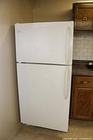 Front view of white Frigidaire refrigerator showing top freezer and larger fridge compartment below