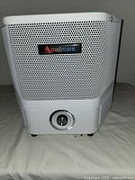 Front view of Amaircare air cleaner showing perforated metal casing with logo.