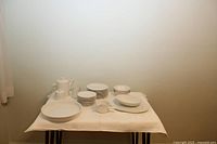 Wide shot of full Johnson Brothers Athena Ironstone dinnerware set displayed on table, showing all included pieces: plates, bowls, serving platters, teapot, creamer, sugar bowl, and gravy boat.