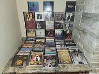 Photo of multiple CD jewel cases showing a wide variety of artists from the 60s, 70s, and 80s, arranged on a marble surface against a wall.