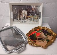 Three serving trays as a group: New York city tray with Marilyn Monroe, silver tray, and Florentine tray with fruit painting