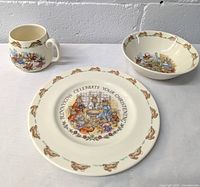 Children's plate, bowl, and handled mug showing front designs with Bunnykins illustrations and rabbit borders.