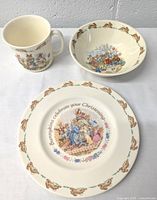 Full view of Bunnykins children's mug, bowl, and plate showing illustrations and border designs