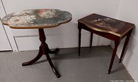 Two wooden side tables displayed side by side, one with rounded edges floral decoupaged top and pedestal base, the other rectangular top with kitten scene and four legs.