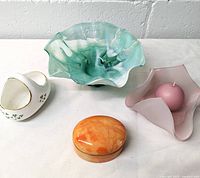 Photo showing the four items: green and white ruffled glass bowl, Royal Tara porcelain basket, light purple glass trinket dish with candle, and Italian alabaster box.
