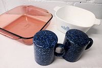 Photo showing cranberry Pyrex casserole dish, white Corning Ware Blue Cornflower casserole dish, and two blue speckled Otagiri salt and pepper shakers