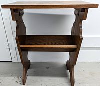 Front view of the walnut vintage library table showing rectangular top and book rack below.
