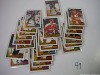 Photo showing 1987 Topps hockey cards spread out, featuring several players and teams in good condition with vibrant colors and no visible creases.