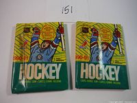 Two unopened 1990-91 OPC hockey card wax packs showing front packaging and colors with hockey player illustration and NHL/NHLPA logos.