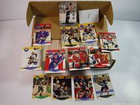 Box containing two stacks of hockey cards along with loose cards from the 1990-91 Pro Set Series 1 and 2 sets, displayed on table.