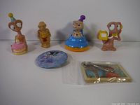 Overview of four E.T. figurines, keychain, and round button, showing lot contents