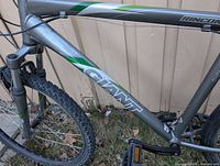 Close-up photo of the bike frame showing the 'GIANT' logo and Rincon model sticker on gray metal frame with minor wear.