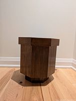 Front view of the wooden planter showing the octagonal shape and medium brown wood grain finish