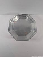Top view of a single octagonal transparent glass plate showing flat surface and edges
