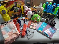 Full lot overview showcasing various toys, stuffed animals, books, Nerf gun, and bubble container