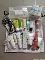 Full lot contents including assorted beauty sample tubes, opened nail tips, and unopened Ivory soap pack photographed to show all items.