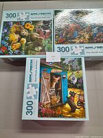 Photo showing three puzzle boxes, each 300 pieces, with colorful animal scenes on the covers.