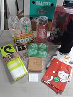 Photo showing all the cat-themed items arranged on a table including water bottle, coasters, glasses, velvet cat, hooks, towels, and paper clips.