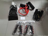 All items arranged on floor including water bottle bag, resistance band, two hand grips, and skip rope, shown from above