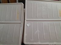 Top view photo of two white Ikea Dilling storage bin lids with a ridged pattern.