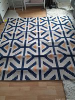 Full top view of the Ikea rug showing the geometric blue, yellow, and white pattern.