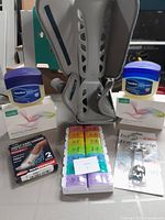 Photo of Vaseline jars, hearing amplifiers, pill organizer, air boot, and adult cast covers
