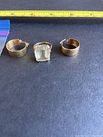 Three items on black background under ruler showing size reference