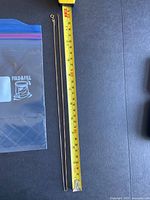 Full length of gold box chain necklace laid alongside measuring tape showing approximately 24 inches