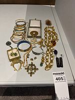 Overall view of the lot on white surface showing bangles, necklaces, earrings and brooches