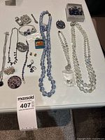 Full view of costume jewelry lot showing necklaces, earrings, brooches, and boxes.