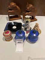 Full lot including elephant bookends, blue jars, black candle holder, two porcelain figurines, and decorative container