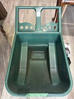 Top view of green PVC lawn cart showing interior tub and handle with grip holes.