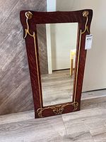 Full front view of the rectangular mirror with dark wooden frame and gold decorative elements.