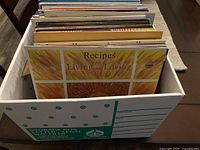 Box of vinyl records with 'Recipes for Living and Loving' album cover visible at front.